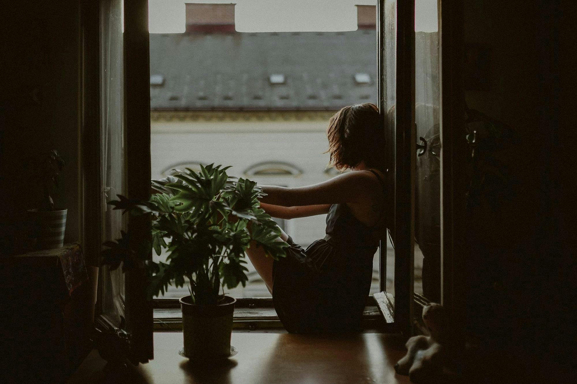 Photo d'une femme assise devant une fenêtre ouverte