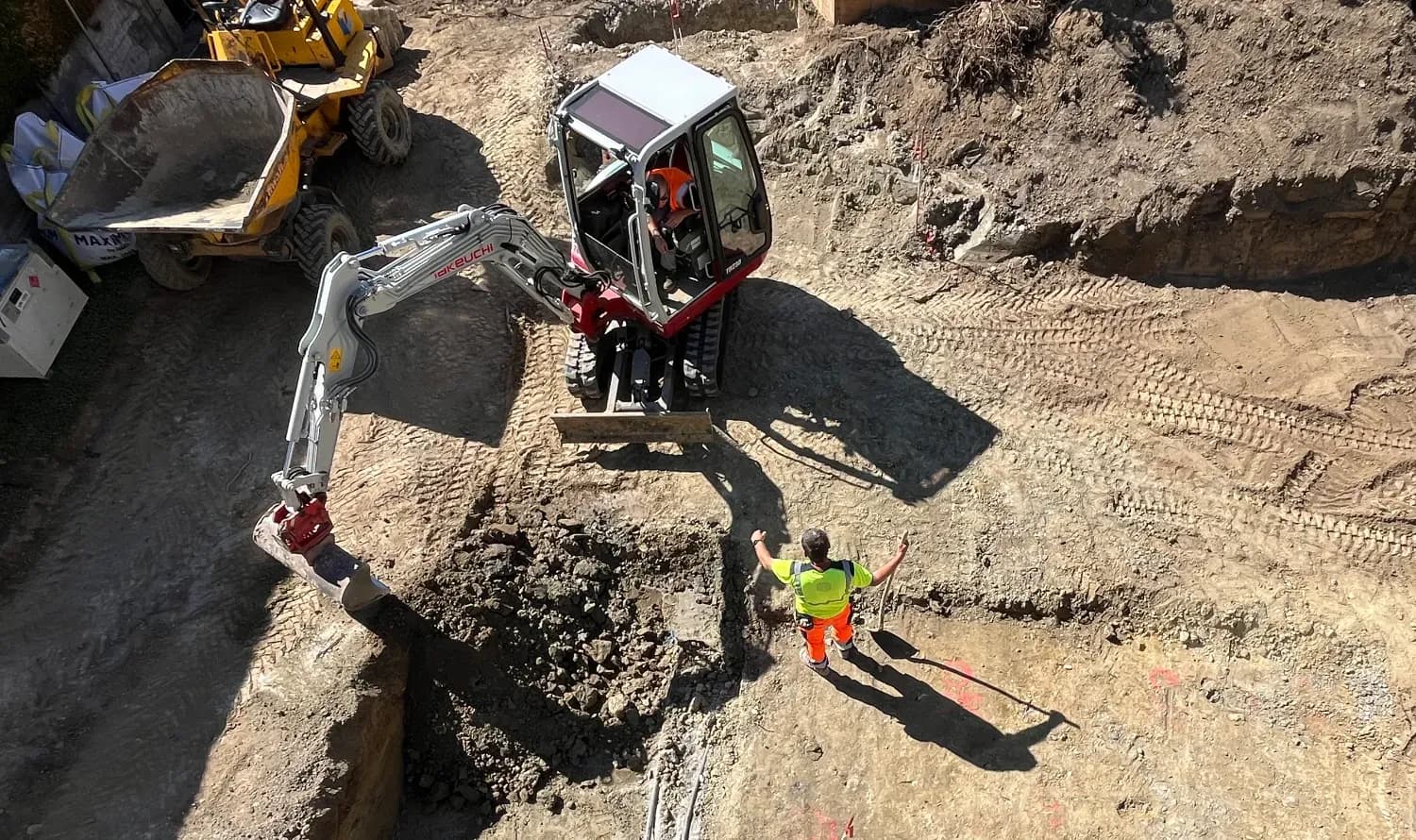 Image d'excavation avec un ouvrier faisant signe à une pelle mécanique